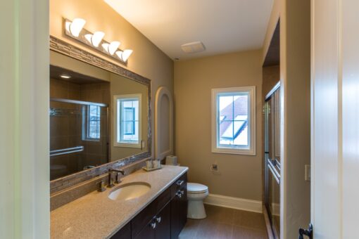 Presidio bathroom with dark vanity and arched mirror