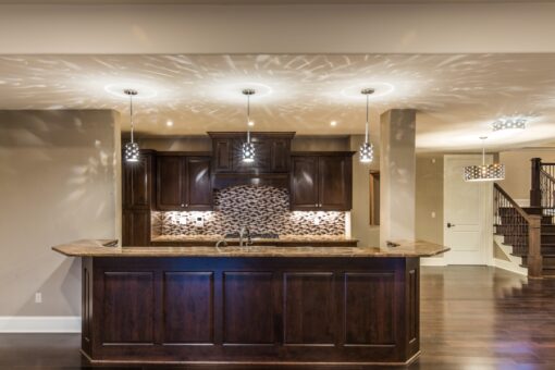 Presidio lower-level bar with dark cabinetry and mosaic backsplash