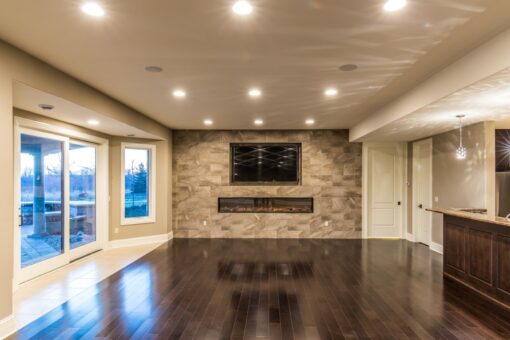 Presidio lower-level family room with stone fireplace wall
