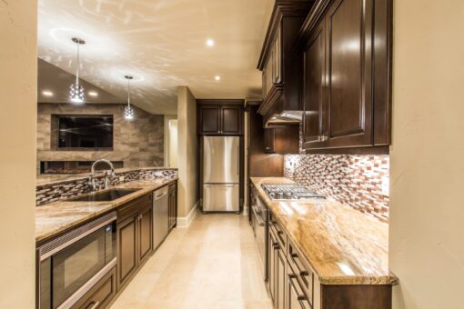 Presidio lower-level kitchen with dark cabinetry and mosaic backsplash