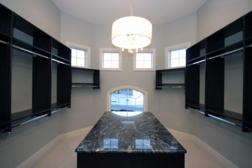 Haven walk-in closet with granite island and chandelier