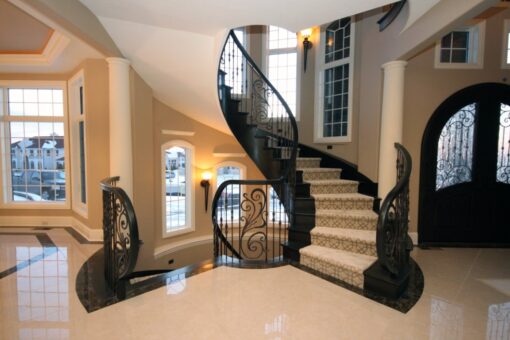 Haven curved staircase with iron railing in the foyer
