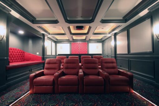 Haven home theater with red recliners and coffered ceiling