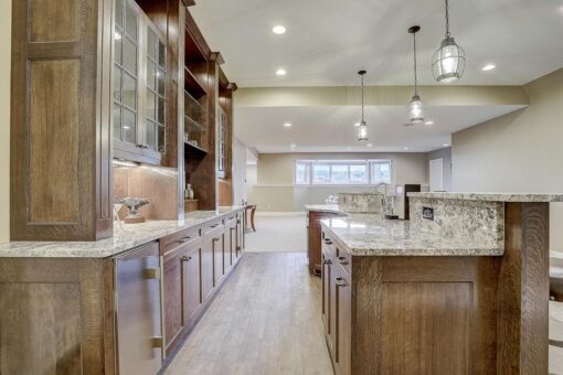 Wildwood lower-level bar with wood cabinetry and granite