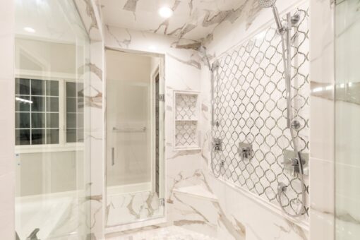 Woodland primary bath marble shower with mosaic accent