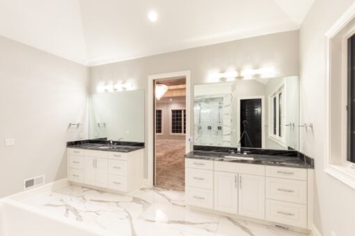 Woodland primary bath double vanity with black counters