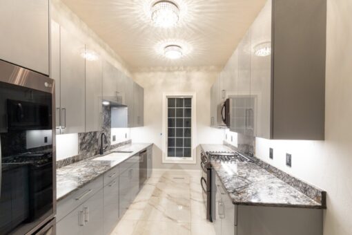 Woodland kitchen with white cabinetry and windows
