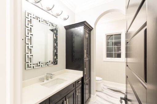 Woodland bathroom with mosaic-framed mirror and dark cabinet