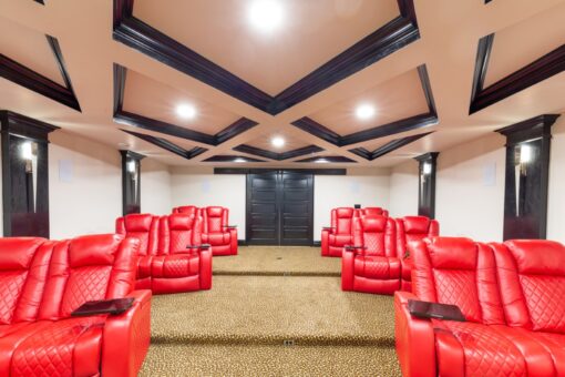 Woodland home theater with red recliners and stepped seating