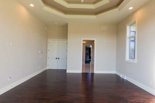 Callista bedroom with tray ceiling and hardwood floors