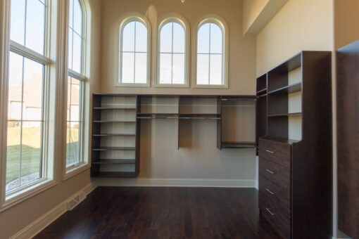 Callista walk-in closet with dark built-ins and arched windows