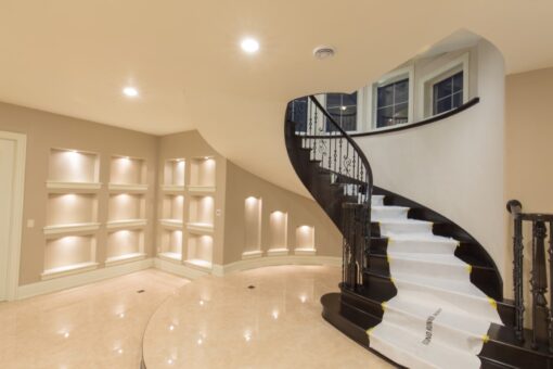 Callista lower-level curved staircase with lit niches