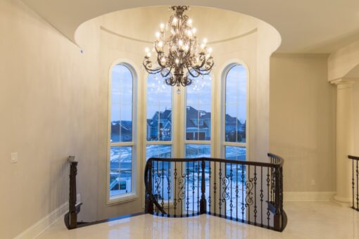 Callista loft with chandelier and two-story arched windows