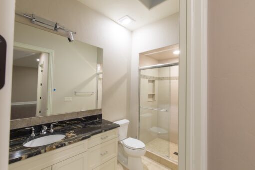 Callista bathroom vanity with dark granite and glass shower