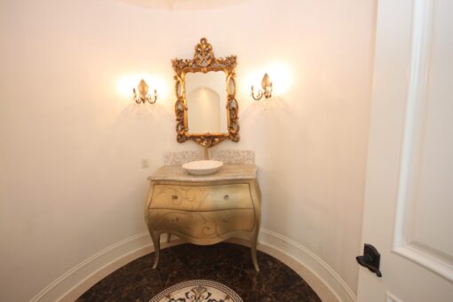 Haven powder room with gilded mirror and painted vanity