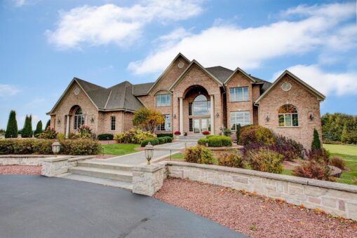 Brookridge custom home by Kingfogl, front elevation with brick and stone exterior and landscaped drive