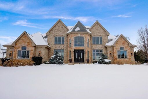 Ridgeview custom home by Kingfogl, front elevation with stone exterior in winter