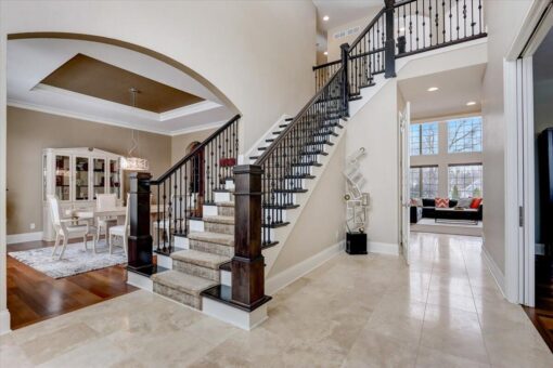Ridgeview foyer staircase with iron railing and arched opening