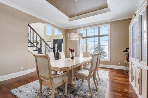 Ridgeview dining room with tray ceiling and staircase view