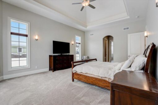 Ridgeview bedroom with tray ceiling and ceiling fan
