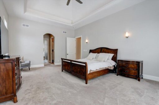 Ridgeview bedroom with wood bed and arched doorway