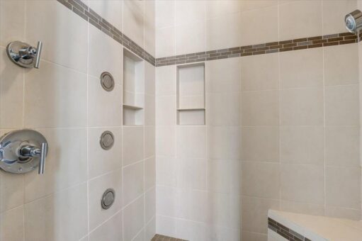 Ridgeview tile shower with body sprays and mosaic band