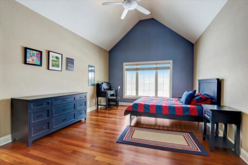 Ridgeview bedroom with navy vaulted wall and hardwood floors