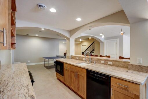 Ridgeview lower-level kitchen with maple cabinetry and arched openings