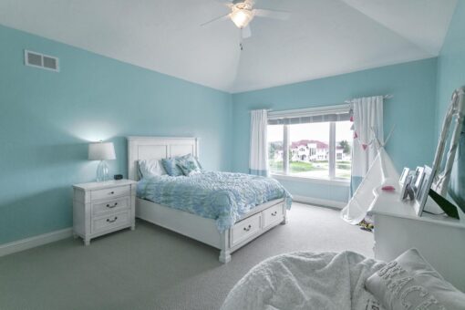 Bradon bedroom with light blue walls and vaulted ceiling