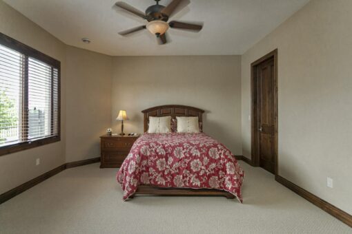 Bradon bedroom with tray ceiling and wood bed