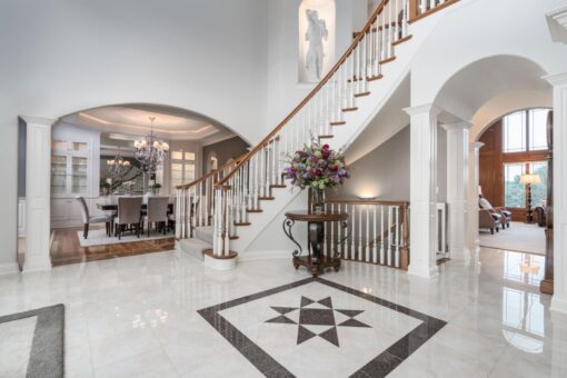 Brookridge foyer with inlaid marble floor and curved staircase