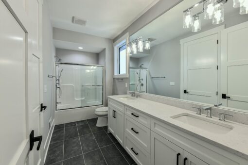 Hawks Ridge bathroom with glass tub-shower and white vanity
