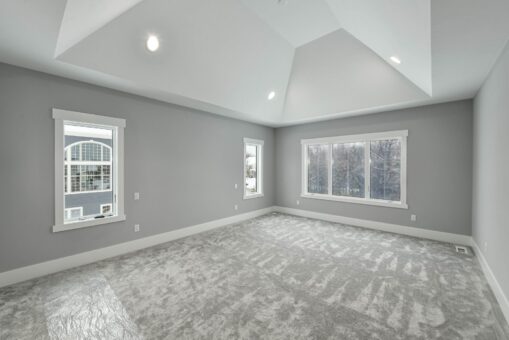 Hawks Ridge primary bedroom with tray ceiling and windows