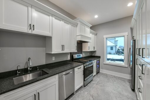 Hawks Ridge kitchen with white cabinetry and black counters
