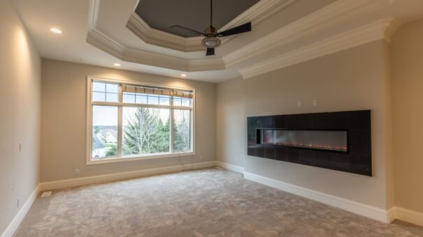 Davidson primary bedroom with tray ceiling and linear fireplace