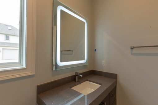 Ravenna bathroom with lit mirror and dark counter