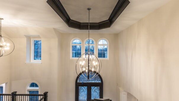 Davidson loft with tray ceiling and chandelier above arched windows