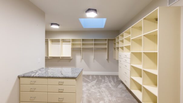 Davidson primary closet with built-in shelving and skylight