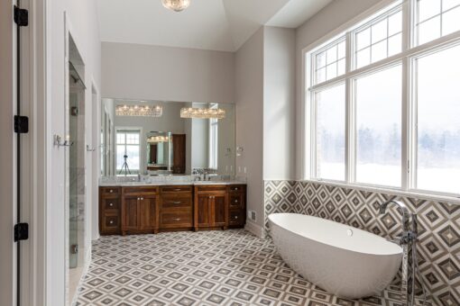 Birchwood primary bath with freestanding tub and patterned floor