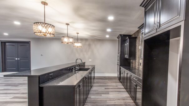 Davidson lower-level bar with dark cabinetry and pendant lights