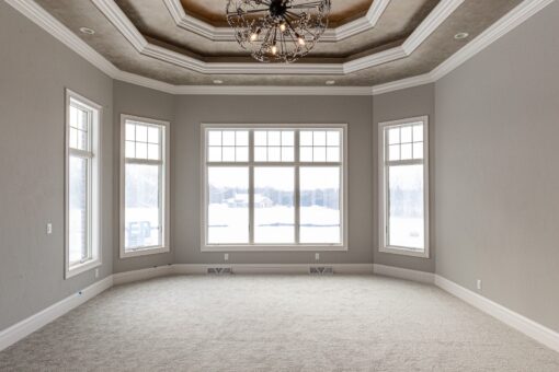Birchwood primary bedroom with bay of windows and tray ceiling