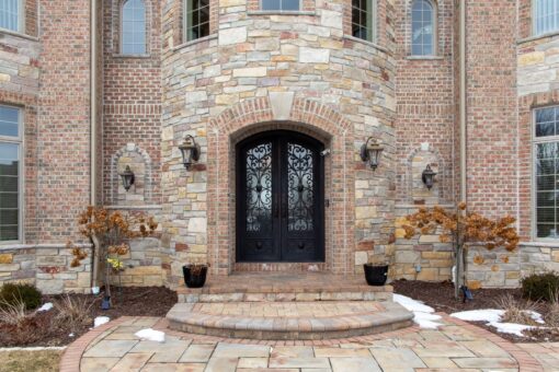 Summerhill stone entry with arched iron doors