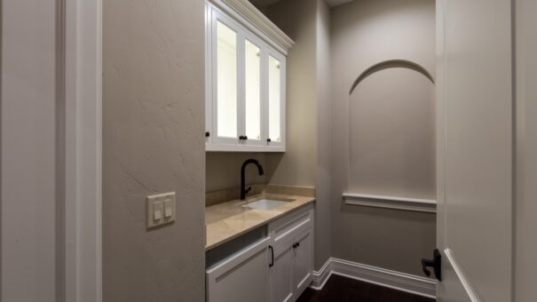 Bella Haven coffee bar with white cabinetry and arched niche