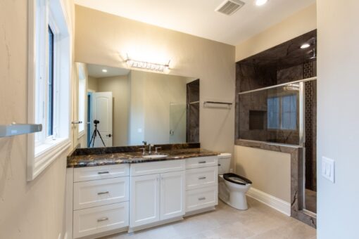Shire bathroom with white double vanity and dark granite