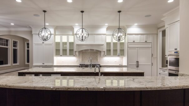 Bella Haven white kitchen with granite island and lantern pendants