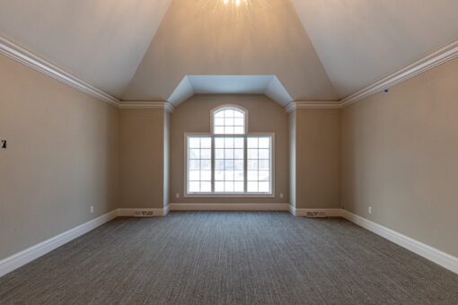 Birchwood bedroom with vaulted ceiling and arched window