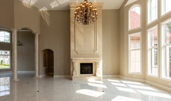 Shire great room with cast stone fireplace and chandelier