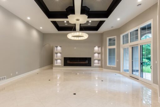 Shire lower-level family room with ring chandelier and fireplace