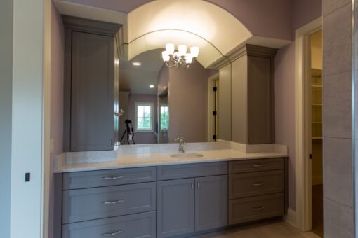 Grand Haven double vanity with gray cabinetry and arched mirror nook