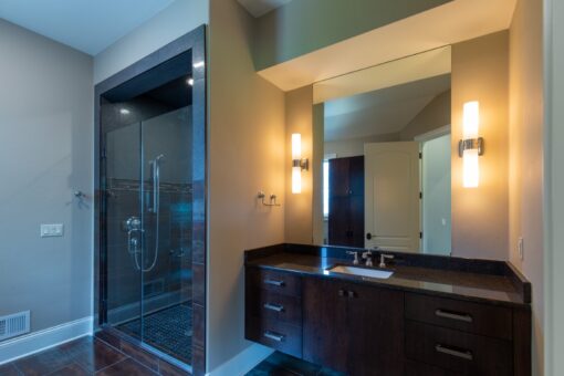 Grand Haven bathroom with dark vanity and glass shower